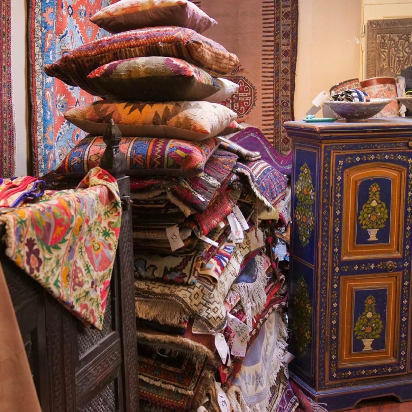 Kilims, cushions and painted chests stacked inside the gallery